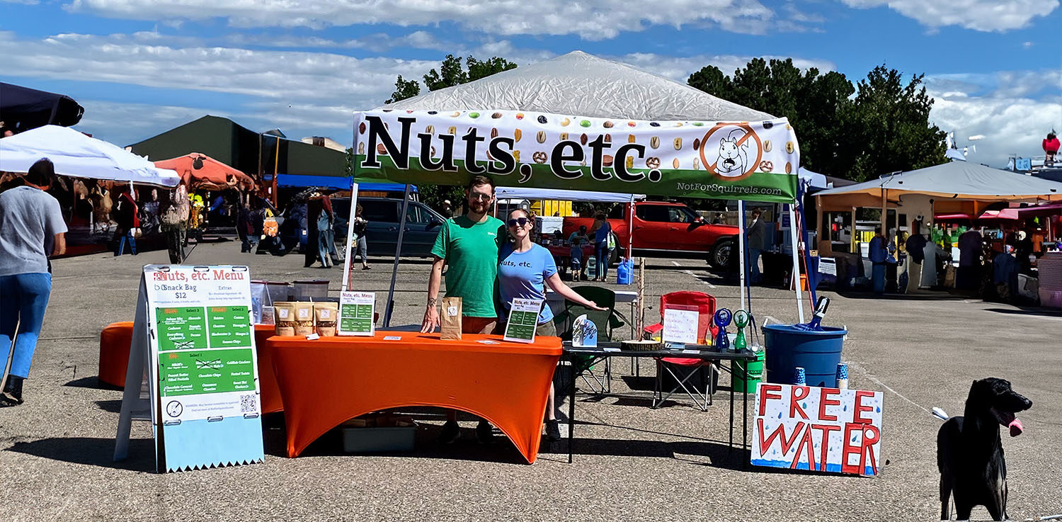 The owners of Nuts, etc. standing behind their booth.